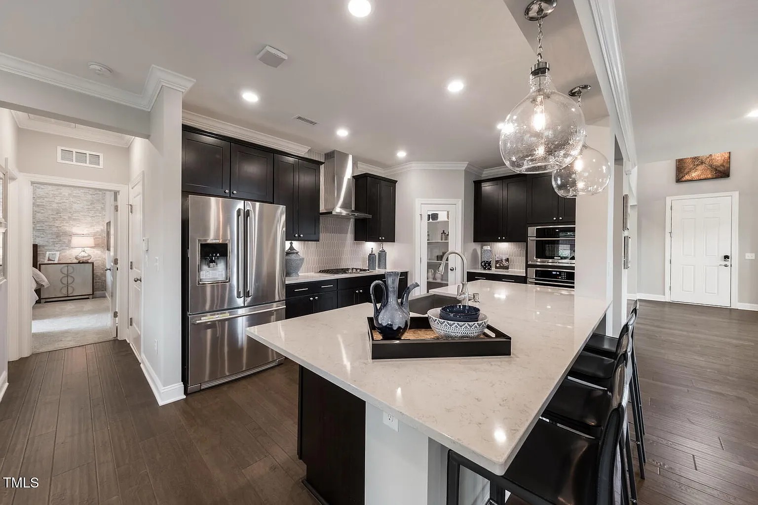 Modern kitchen with espresso cabinets, quartz island and glass globe pendants