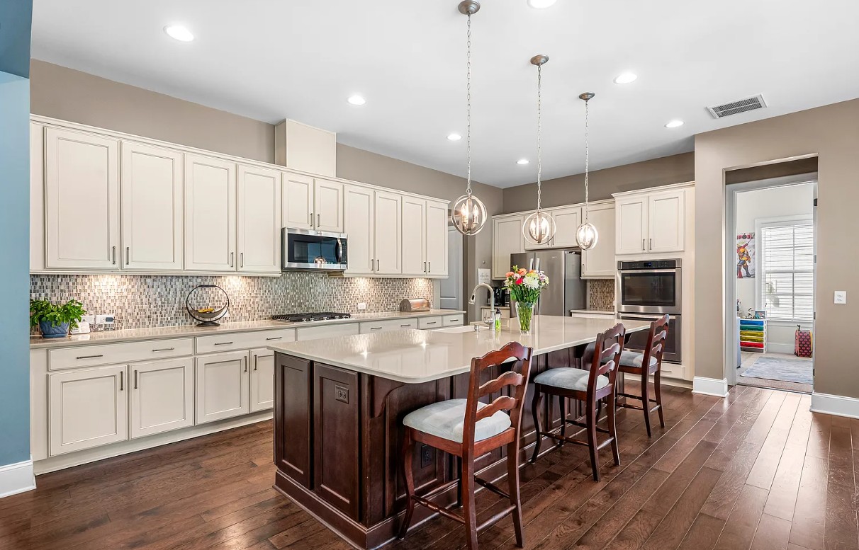 Traditional kitchen with cream cabinets, cherry island and mosaic tile backsplash